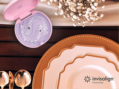The image depicts a collection of tableware items including plates, cups, and a cake stand with a pink lid, arranged on a wooden surface, with a watermark that reads  Invisalign  visible in the bottom right corner.